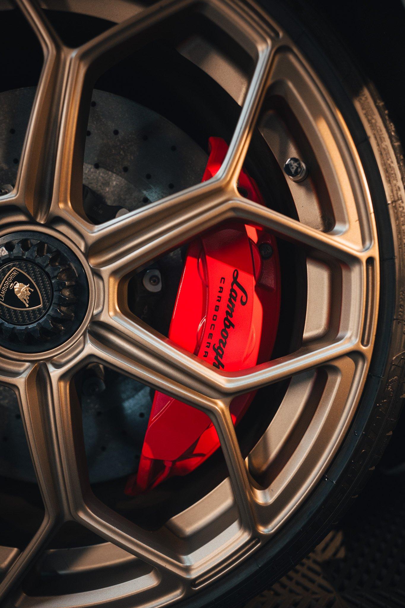 Close-up of a bronze Lamborghini wheel with red caliper and bull crest center cap