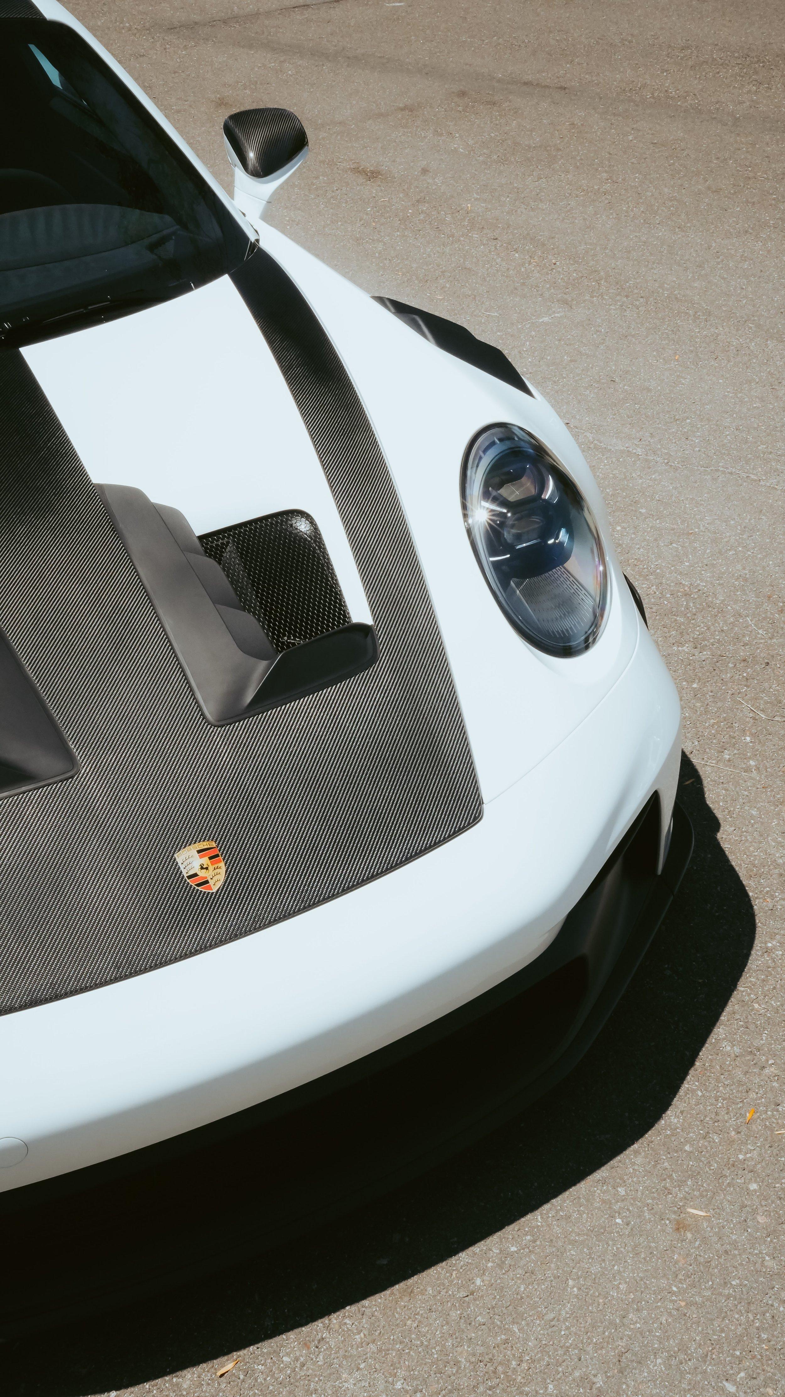 White Porsche 911 GT3 RS front end with carbon fiber hood and headlight, ready for paint protection film